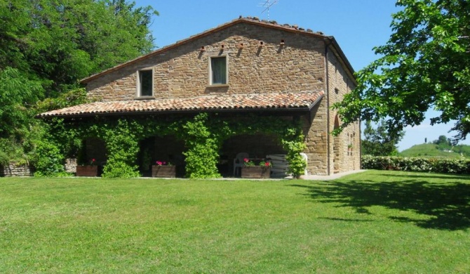 Stone house in the green rolling hills of the Apennines with garden